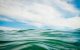 Close-up photograph of ocean wave against the blue sky