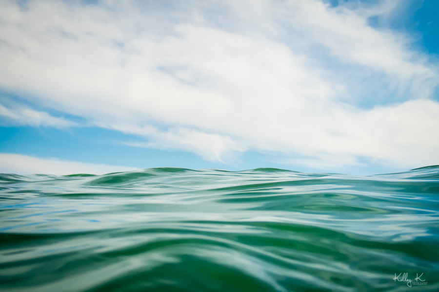 Close-up photograph of ocean wave against the blue sky