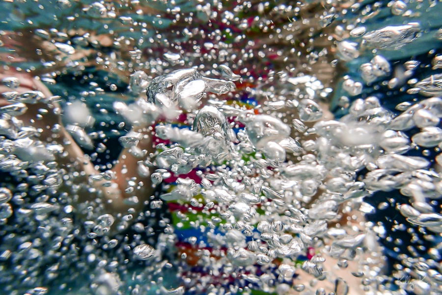 Photograph of tiny underwater bubbles against colorful background